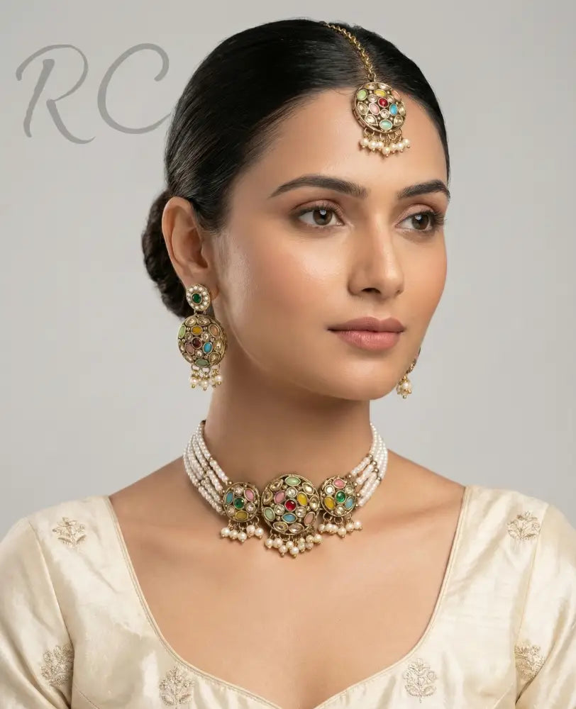 Woman wearing traditional jewelry including a necklace, earrings, and a bindi on a gray background